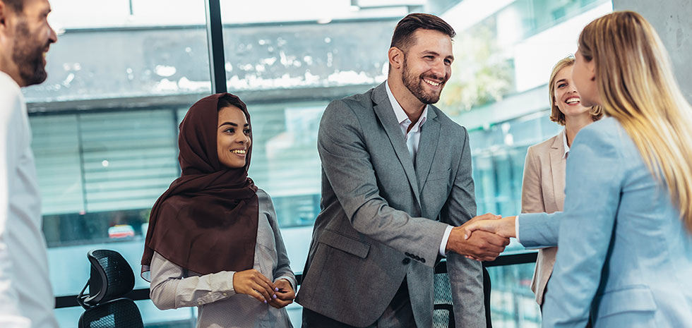 Business people shaking hands in the office. Group of business persons in business meeting.